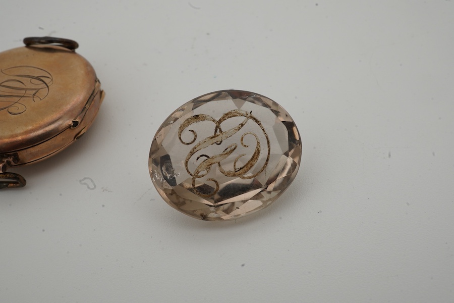 A lady's George V 9ct gold and enamel manual wind wrist watch, no strap, together with an unmounted oval cut quartz, carved with monogram, 19mm by 16mm.